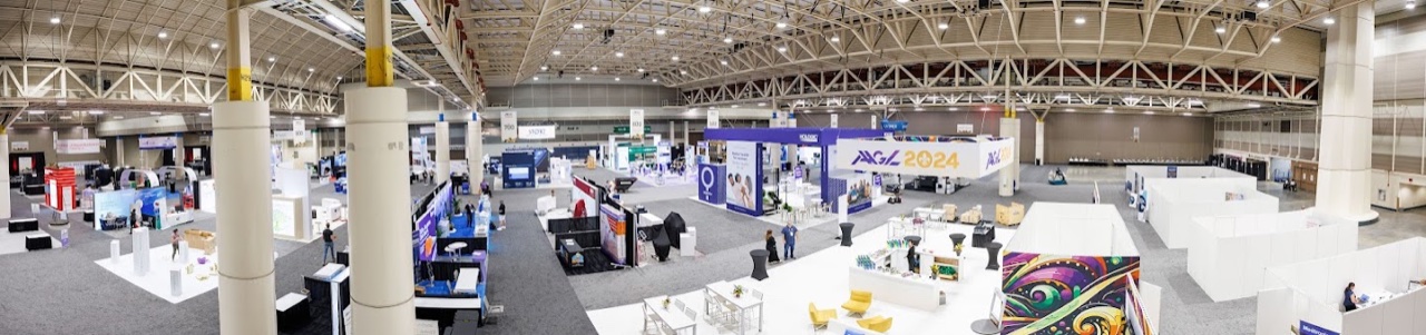 Panoramic view of AAGL 2024 exhibit hall with branded signage and booth installations